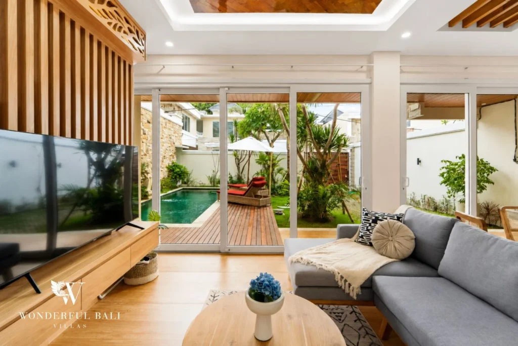 Living room looking out to the pool and garden in a 3-bedroom villa in Tumbak Bayuh Bali