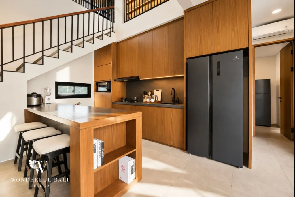Oak kitchen with breakfast bar and tall fridge in a 3-bedroom villa in Jimbaran Bali