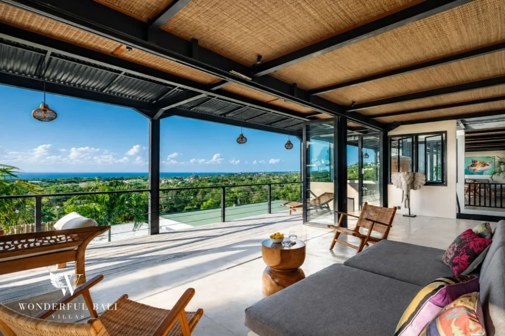 Open-air upper lounge with timber chairs facing the ocean at a 5-bedroom villa in Uluwatu Bali