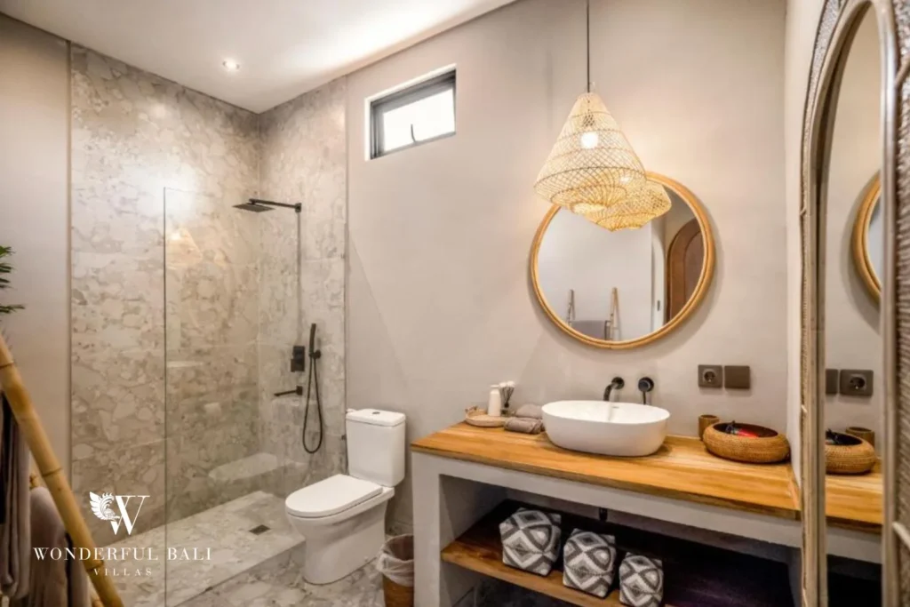 En-suite bathroom with walk-in shower, round mirror and vessel basin in Pererenan Bali