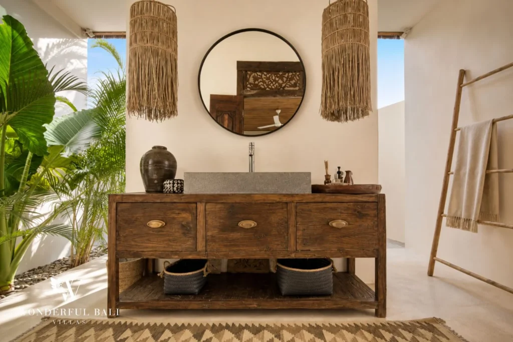 Carved timber vanity with a stone basin and macrame pendants in a 3-bedroom villa in Umalas Bali