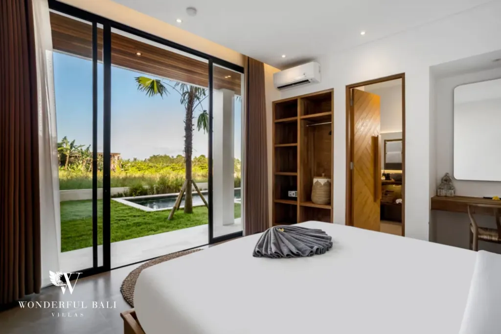 4BR villa for rent in Pererenan — bedroom, sliding doors opening onto the pool lawn