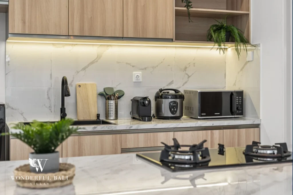 Marble splashback and under-cabinet lighting in the kitchen of a 3-bedroom villa in Kaba-Kaba Bali