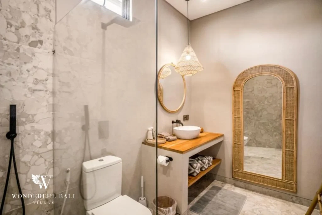Teak bathroom vanity with vessel basin and arched mirror in a 2-bedroom villa in Pererenan Bali