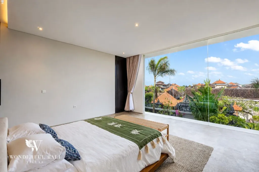 4BR villa for rent in Seminyak — bedroom, bed facing a glazed corner over the rooftops