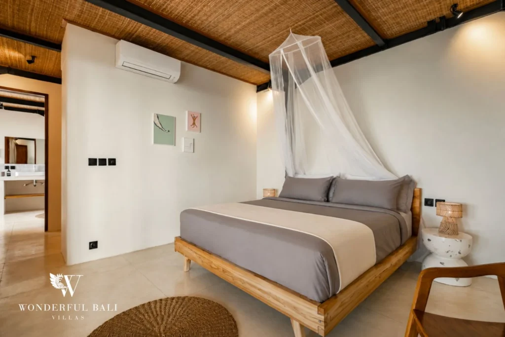 Bedroom with teak platform bed and en-suite in a 5-bedroom villa in Uluwatu Bali