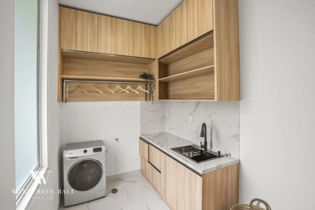 Separate laundry room with washing machine and sink in a 3-bedroom villa in Kaba-Kaba Bali