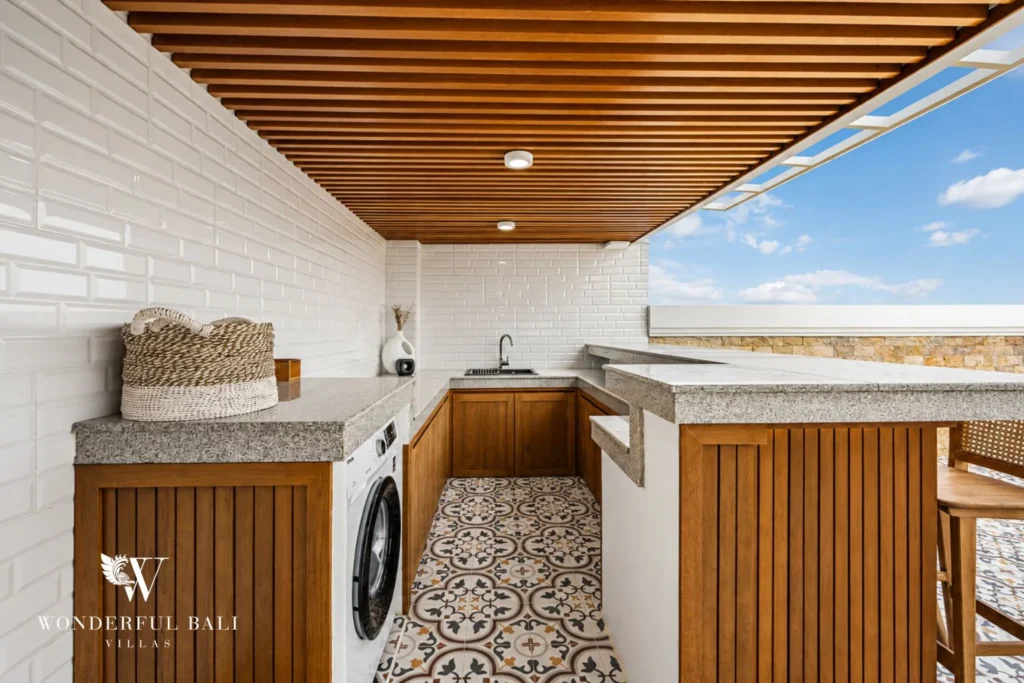 Rooftop wet bar with teak stools and washing machine at a 3-bedroom villa in Tumbak Bayuh Bali