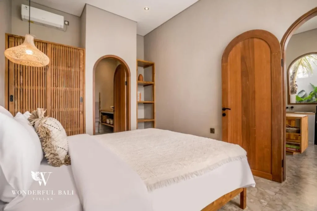 Bedroom with a solid teak arched door and rattan pendant in Pererenan Bali