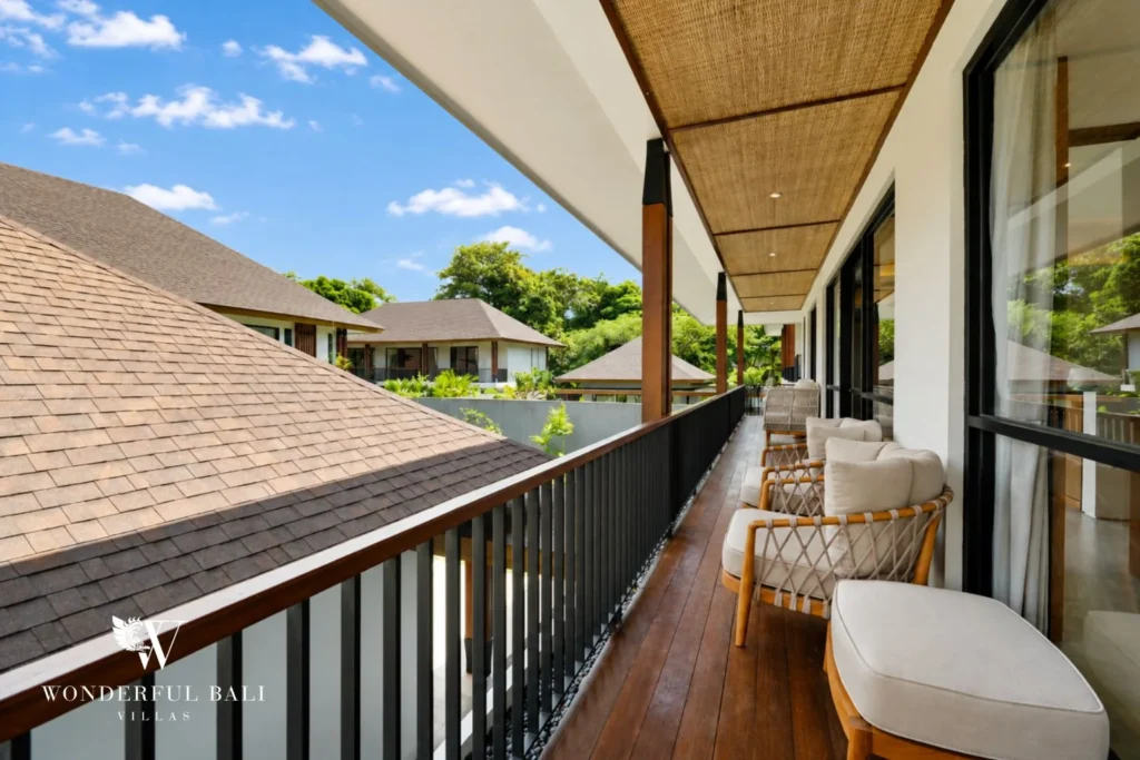 Covered balcony terrace with rattan chairs above the rooftops in Jimbaran Bali