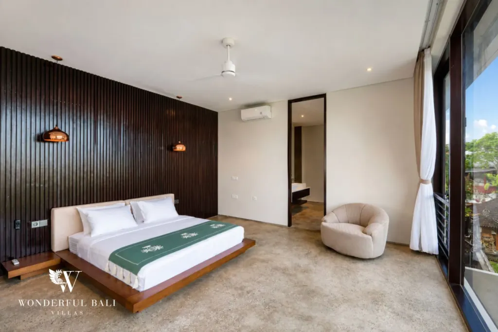 4BR villa for rent in Seminyak — bedroom, bed against a dark timber panel wall