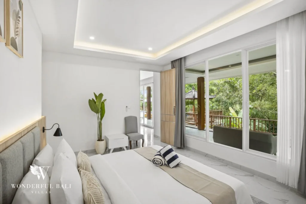 Main bedroom with glass doors onto the deck and jungle in a 3-bedroom villa in Kaba-Kaba Bali