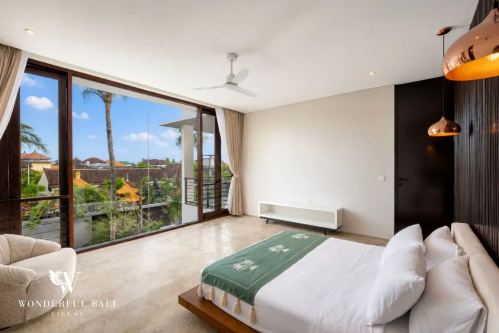 4BR villa for rent in Seminyak — bedroom, doors onto the balcony and an armchair by the glass