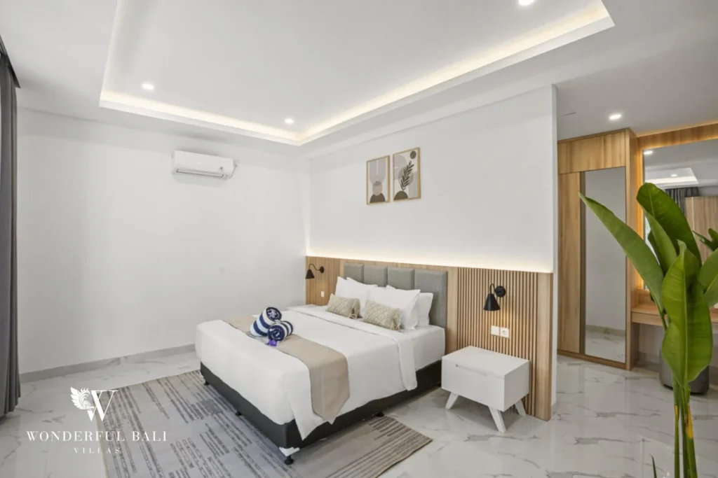 Bedroom with fluted timber headboard panel and mirrored wardrobe in a 3-bedroom villa in Kaba-Kaba Bali
