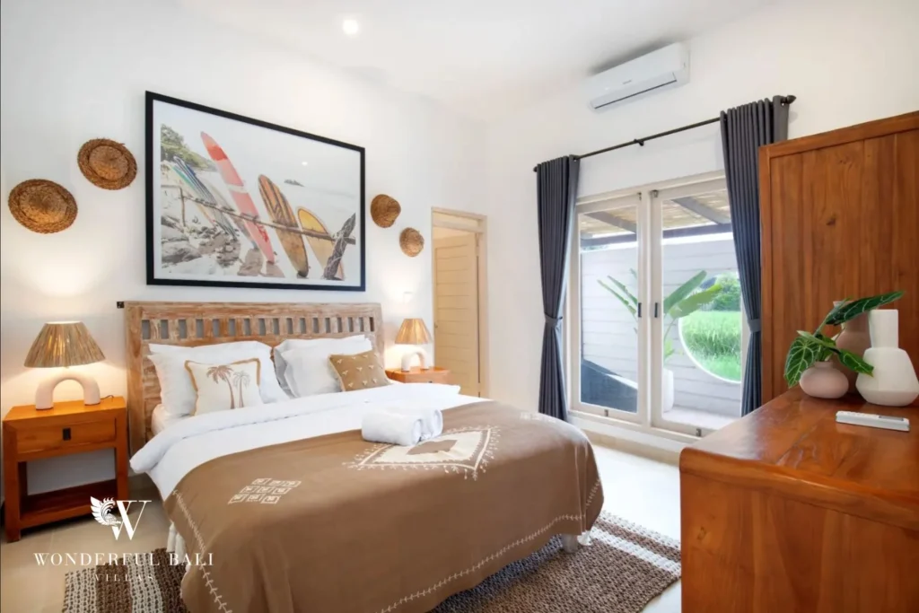 Third bedroom with carved timber headboard facing the rice-field terrace in a 3-bedroom villa in Umalas Bali