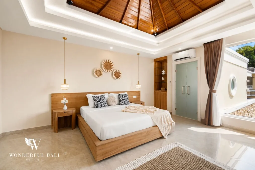 Main bedroom with teak platform bed and smart TV in a 3-bedroom villa in Tumbak Bayuh Bali
