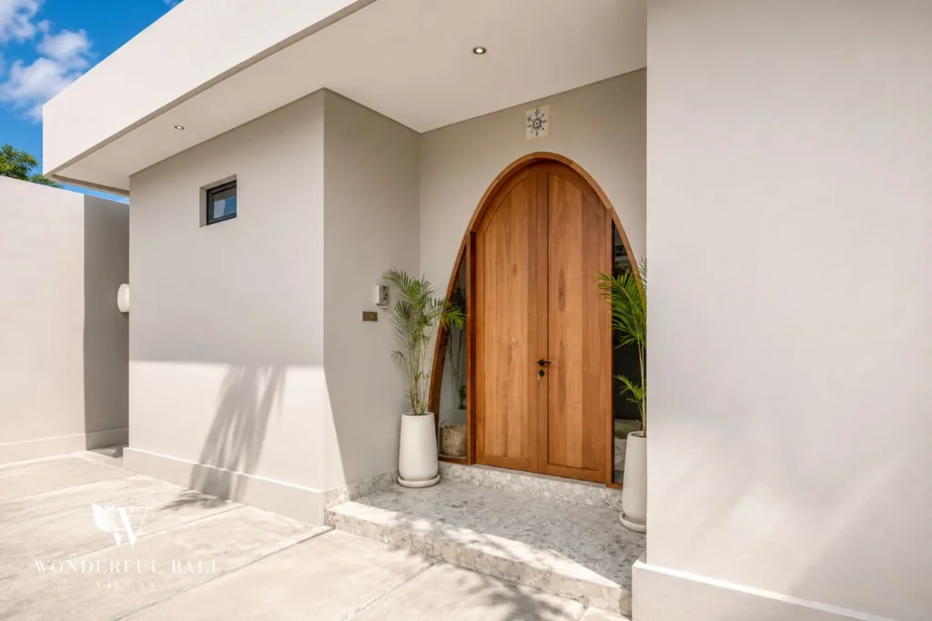 Arched teak entrance door and terrazzo steps at a 2-bedroom villa in Pererenan Bali