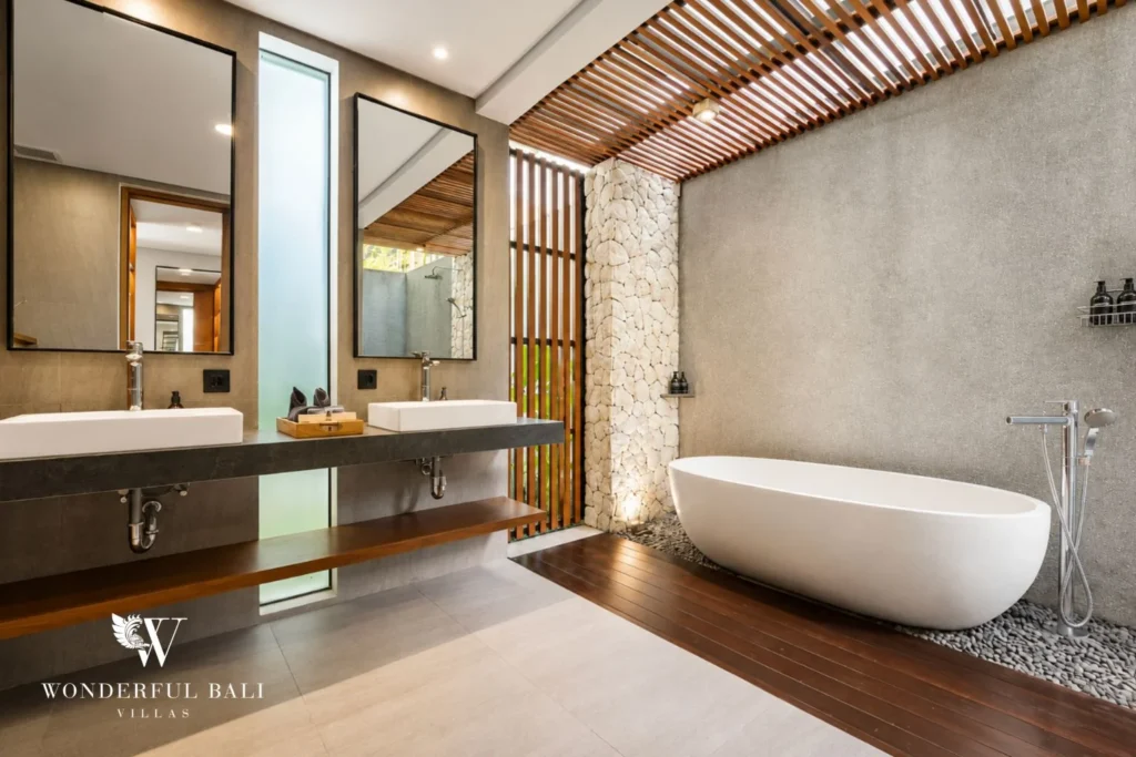 Twin stone vanity and freestanding bathtub under a slatted pergola in a 3-bedroom villa in Jimbaran Bali