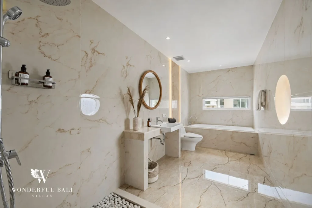 Cream marble bathroom with soaking tub and rain shower in a 3-bedroom villa in Tumbak Bayuh Bali