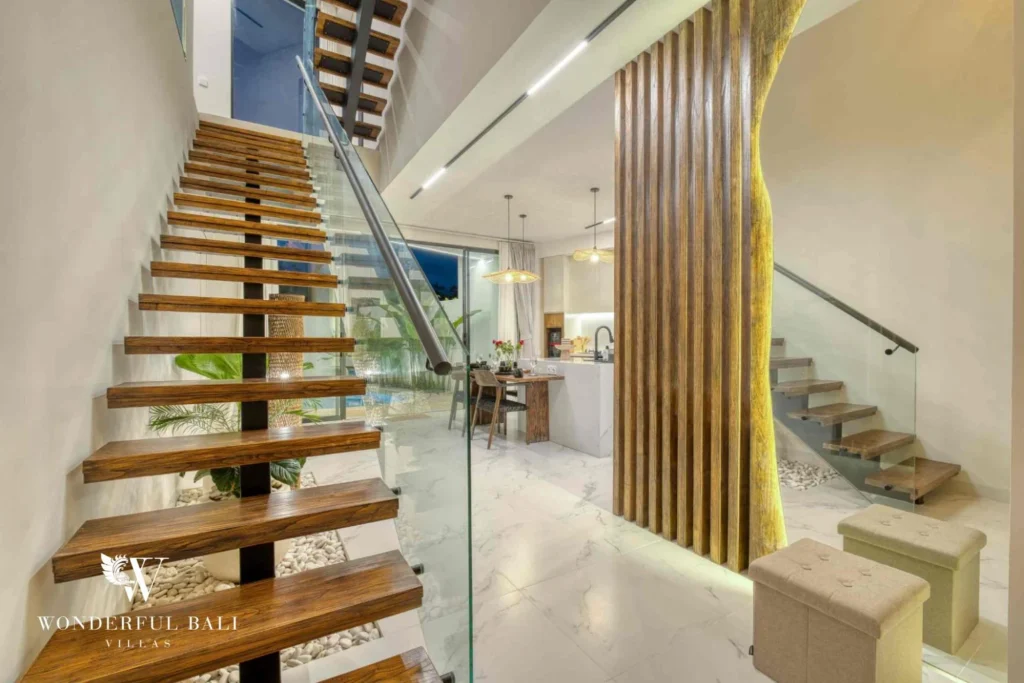 Floating timber staircase with glass rail beside the living room in a 3-bedroom villa near Nusa Dua Bali