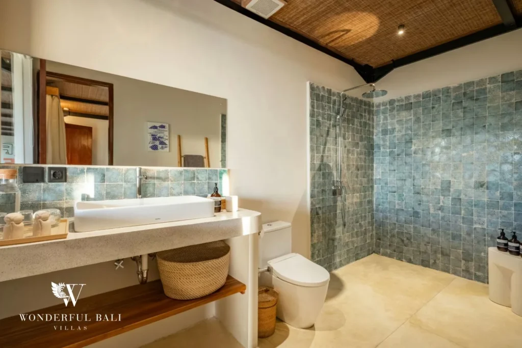 Bathroom with sea-green glazed tile and rain shower in a 5-bedroom villa in Uluwatu Bali