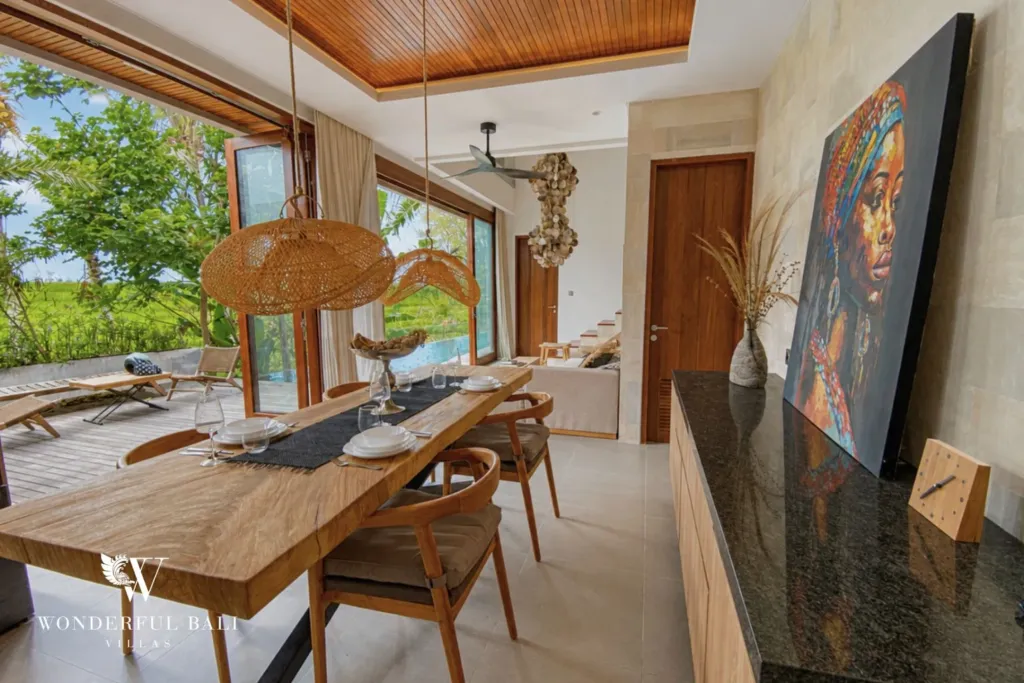 3BR villa for rent in Kedungu — dining, timber dining table with the kitchen beyond