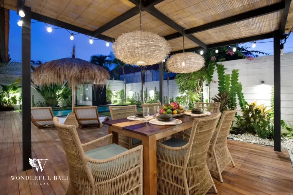 Outdoor dining lit by festoon bulbs at dusk at a 3-bedroom villa in Umalas Bali