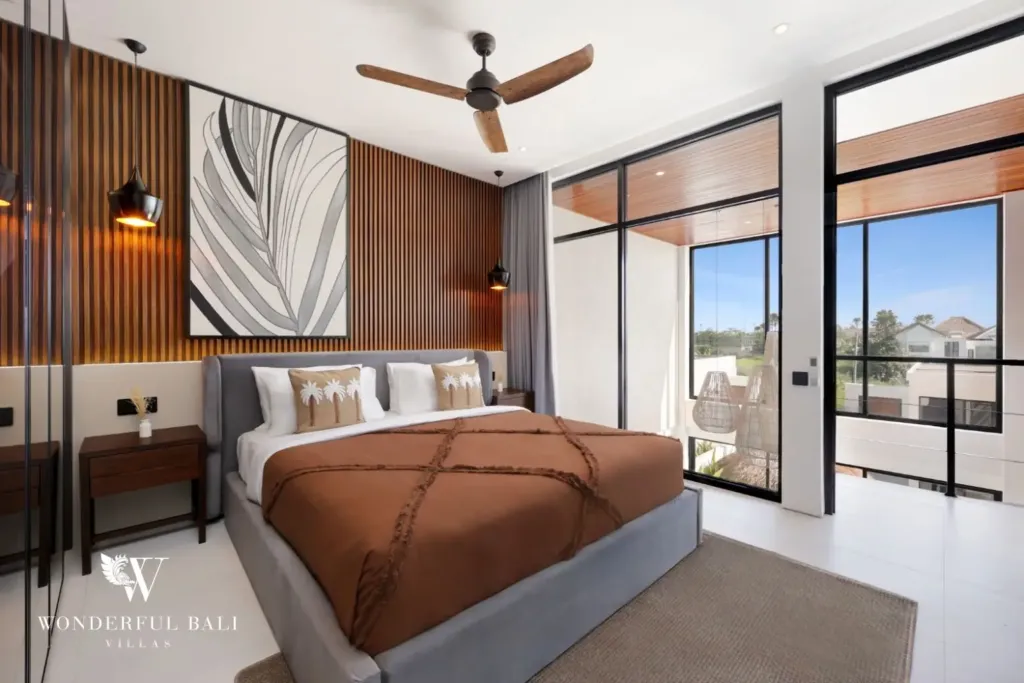 Bedroom with sliding doors onto a balcony at a 3BR villa in Pererenan Bali