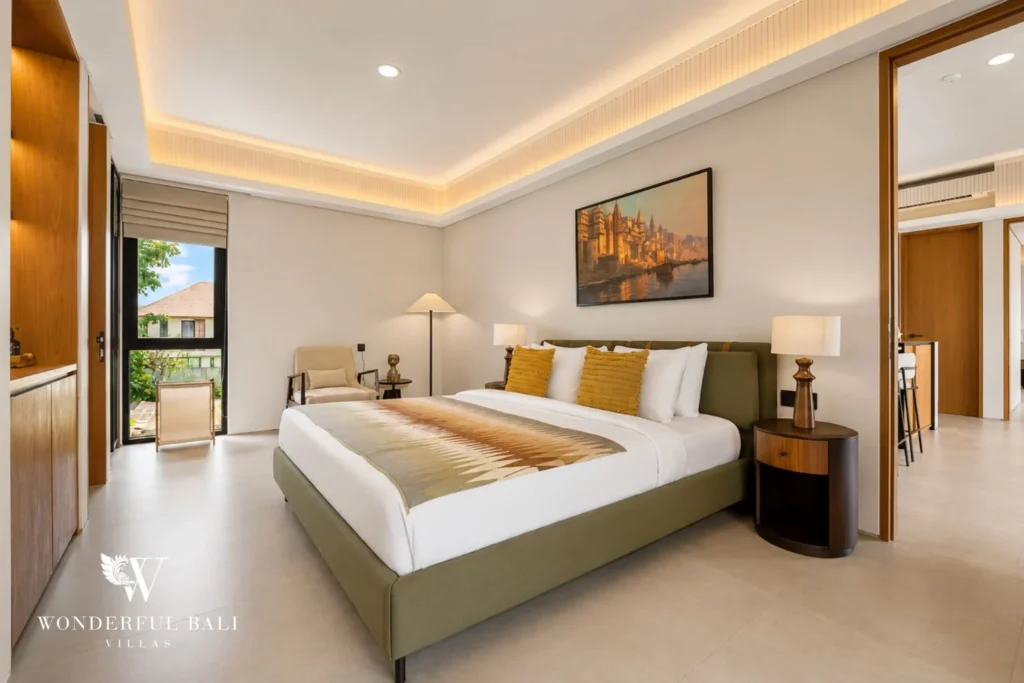 Second bedroom with green upholstered bed and balcony doors in a 3-bedroom villa in Jimbaran Bali