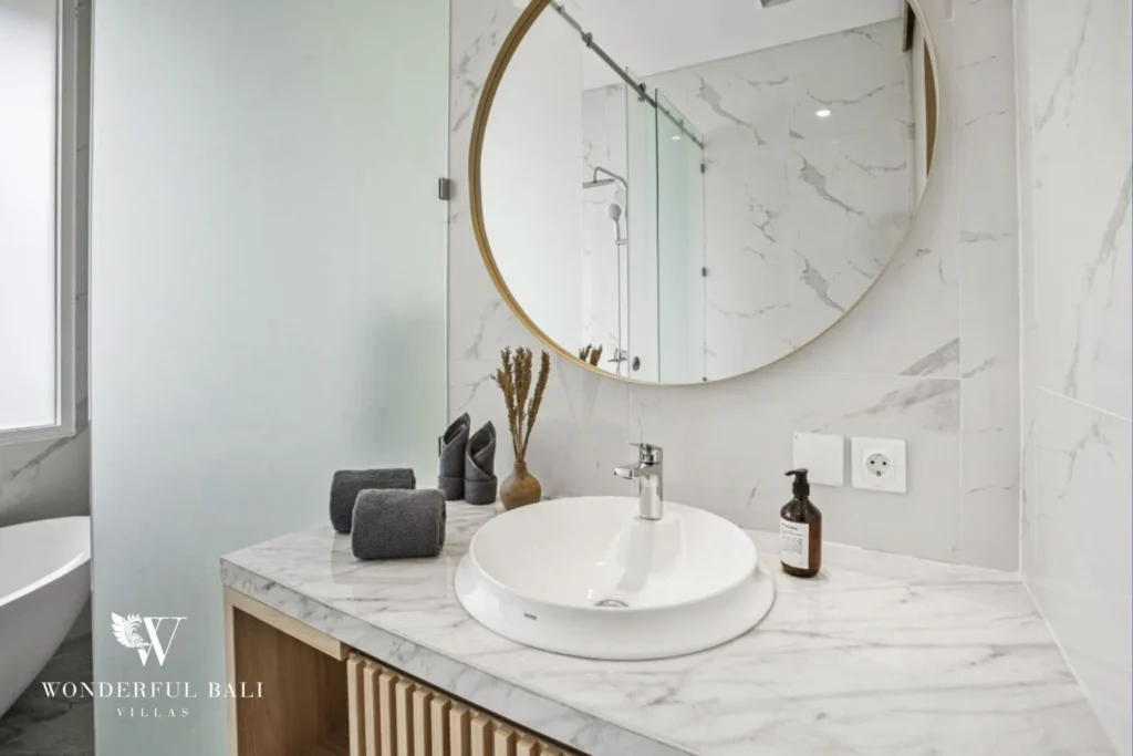 Marble vanity with round brass-framed mirror in a 3-bedroom villa in Kaba-Kaba Bali