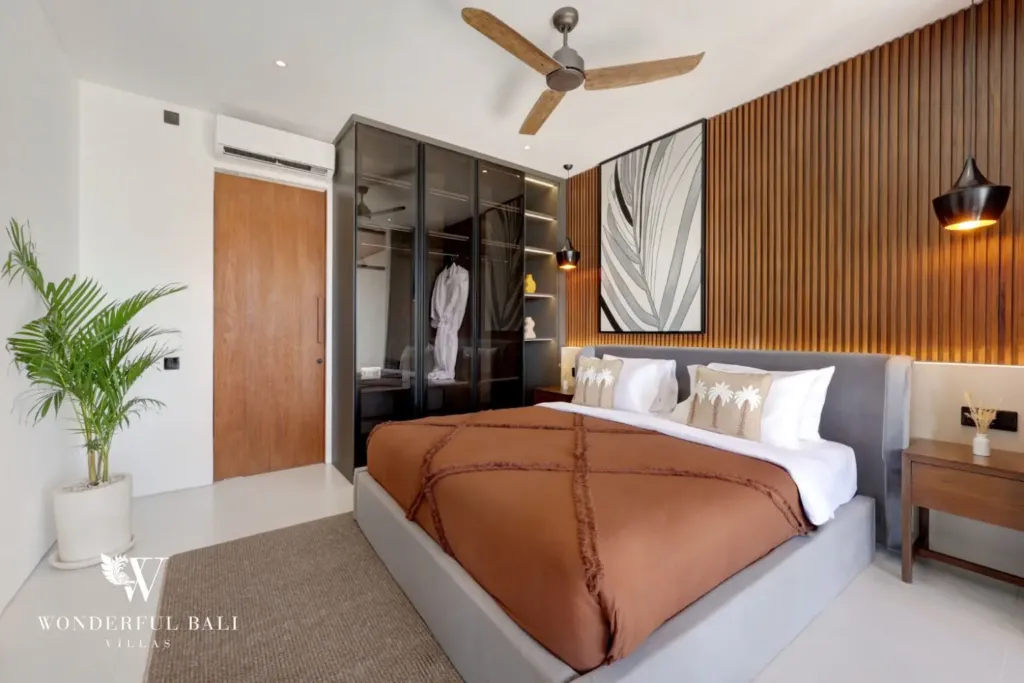 Bedroom with mirrored wardrobe and ceiling fan at a 3BR villa in Pererenan Bali