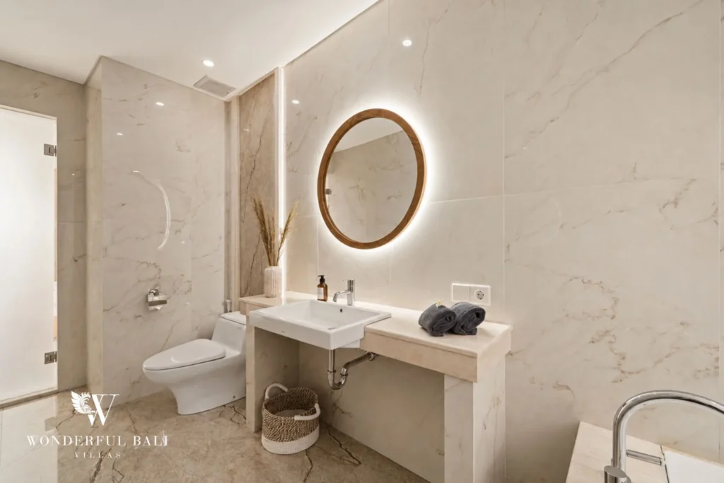 Marble vanity with backlit round teak mirror in a 3-bedroom villa in Tumbak Bayuh Bali
