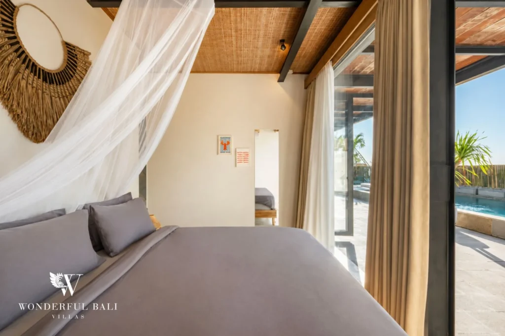 Bedroom with mosquito net looking out to the pool in a 5-bedroom villa in Uluwatu Bali