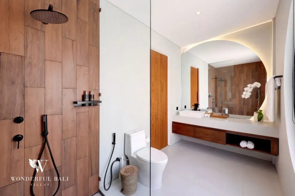En-suite bathroom with rain shower and timber walls at a 3BR villa in Pererenan Bali