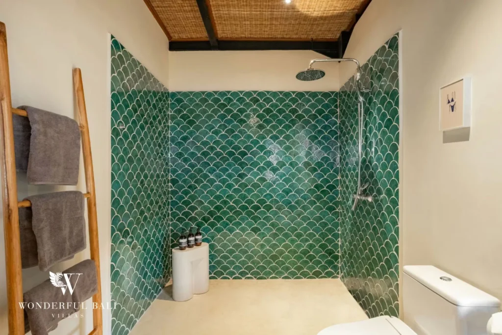 Walk-in rain shower lined in green fish-scale tile in a 5-bedroom villa in Uluwatu Bali