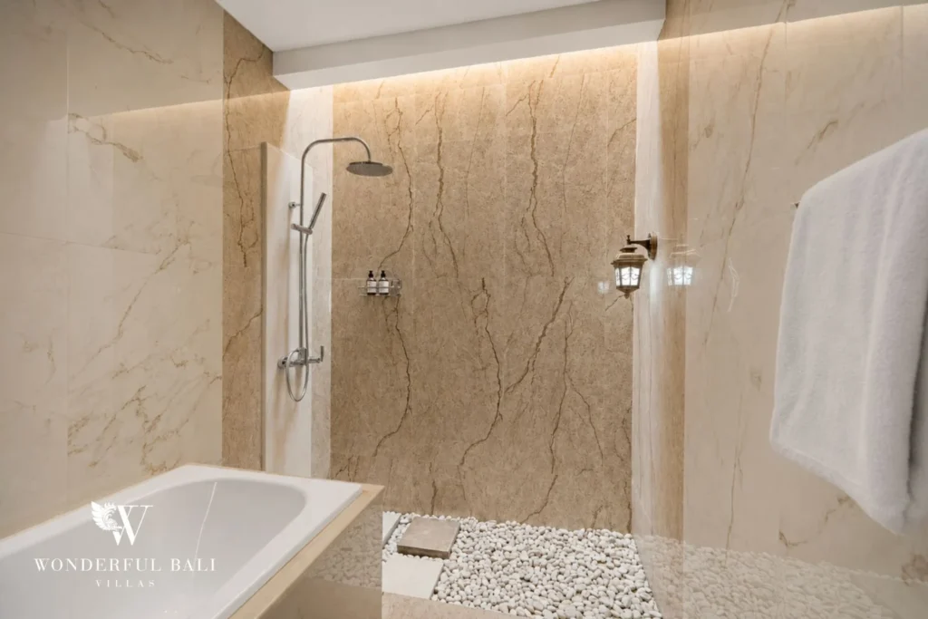 Bathroom with soaking tub and marble rain shower in a 3-bedroom villa in Tumbak Bayuh Bali