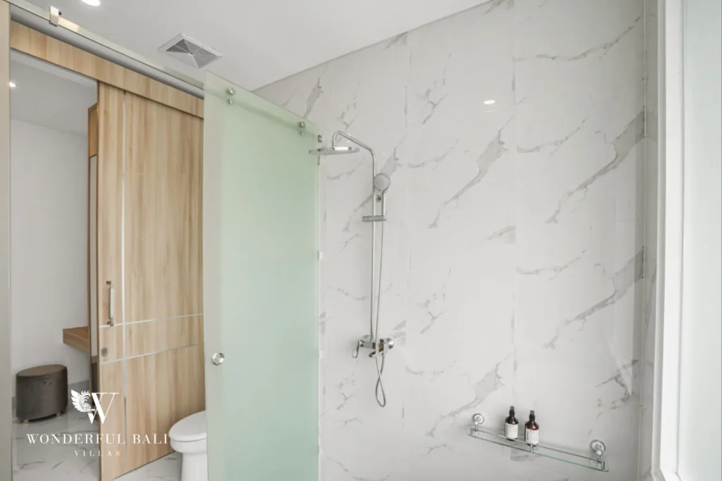 Marble en-suite with rain shower behind frosted glass in a 3-bedroom villa in Kaba-Kaba Bali