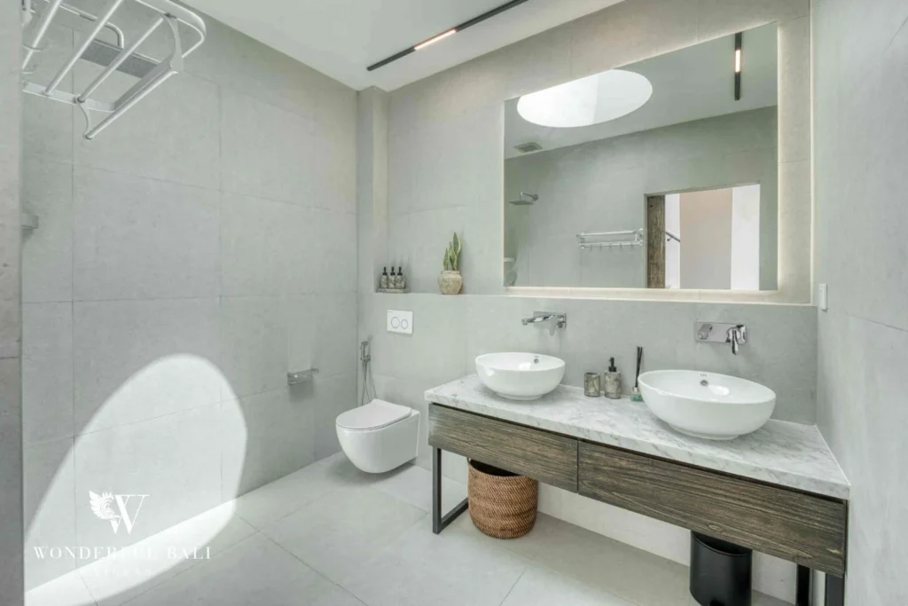 En-suite bathroom with twin vessel basins and a large mirror near Nusa Dua Bali