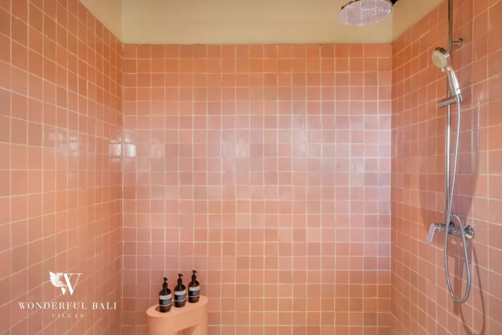 Walk-in shower lined in blush pink glazed tile in a 5-bedroom villa in Uluwatu Bali