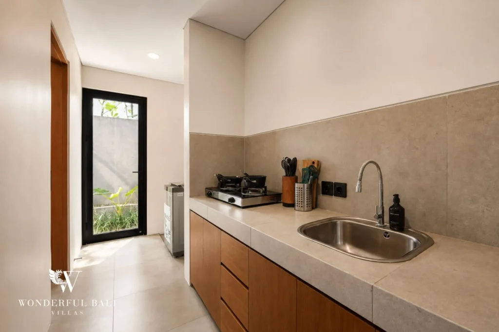 Enclosed wet kitchen with gas hob and sink in a 3-bedroom villa in Jimbaran Bali