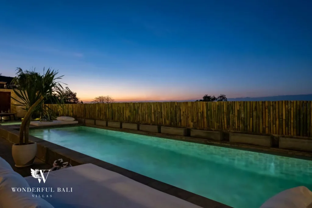 Lit pool behind a bamboo screen at dusk in Uluwatu Bali