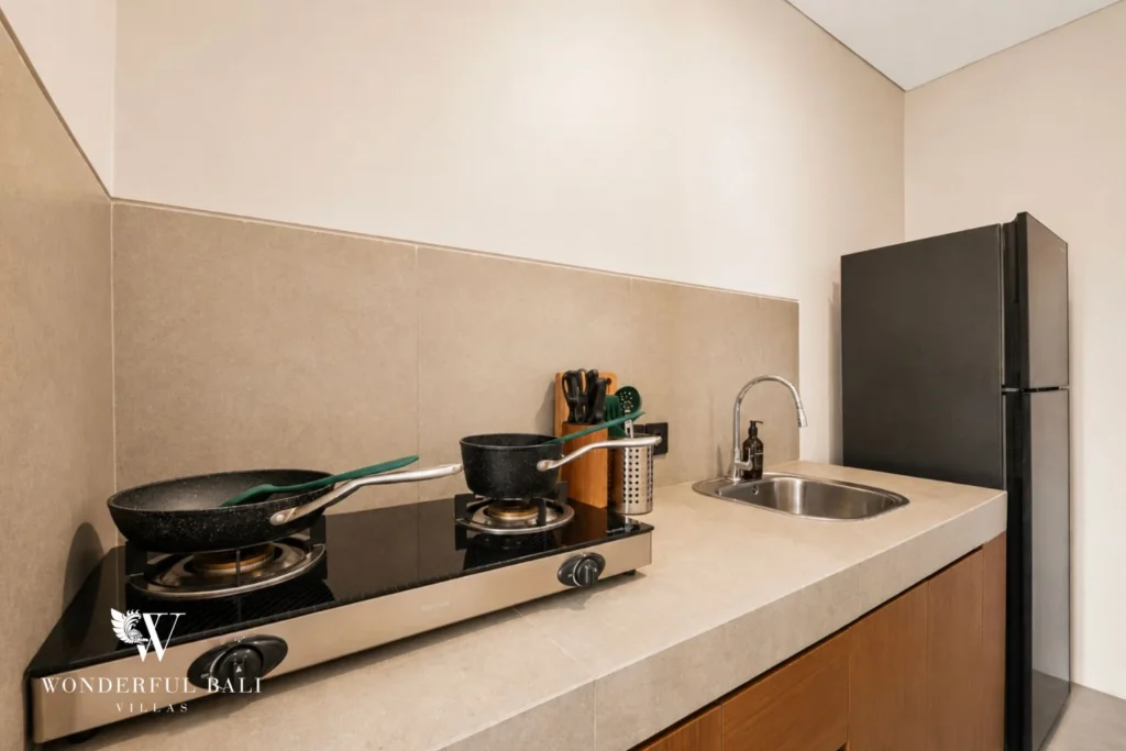 Wet kitchen with gas burners and fridge in a 3-bedroom villa in Jimbaran Bali