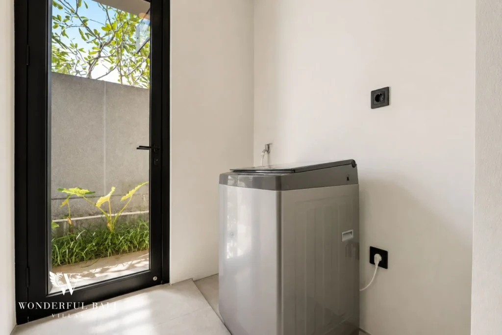 Laundry area with washing machine and light well in a 3-bedroom villa in Jimbaran Bali