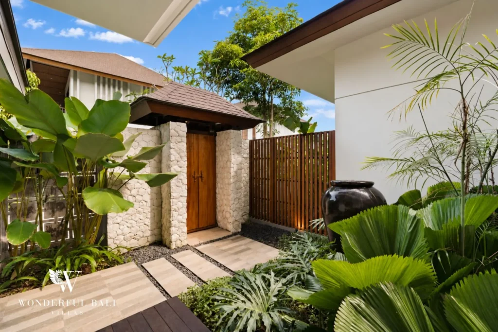 Timber entrance gate framed by tropical planting at a 3-bedroom villa in Jimbaran Bali