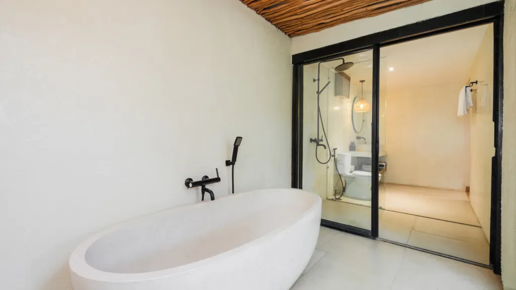 Lexington Palace Villa, Uluwatu — bathroom, freestanding stone bathtub behind sliding glass in an en-suite at Lexington Palace Villa