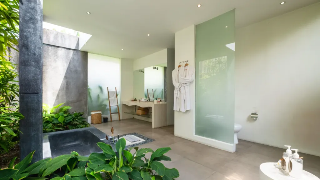 En-suite with a sunken stone bathtub and rain shower at Villa Alice Satu