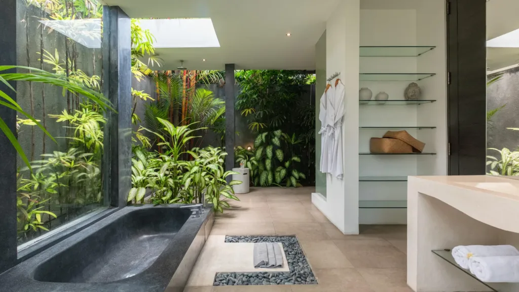 Second en-suite with a sunken stone bathtub in a planted courtyard at Villa Alice Satu