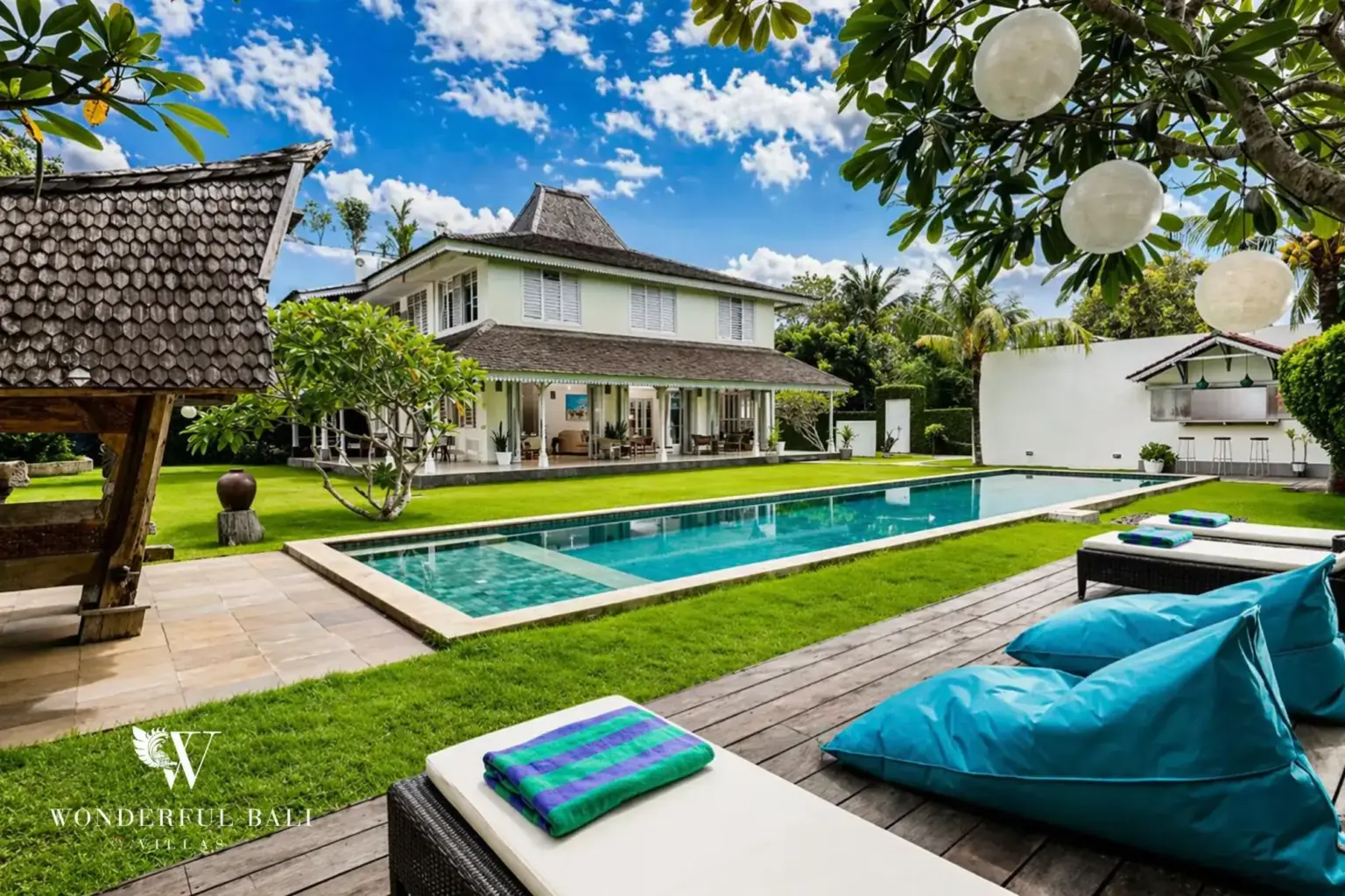 Poolside lawn and bean bags at a Bali villa at midday