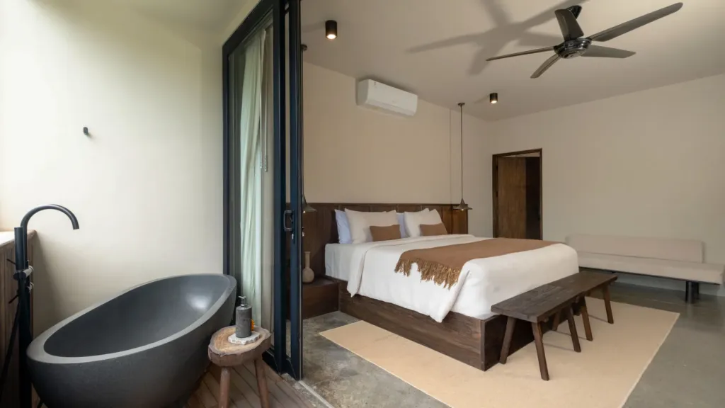 Bedroom 1 with river-stone bathtub on the balcony at Villa Jaxé, a 5-bedroom private-pool villa in Bingin, Bali