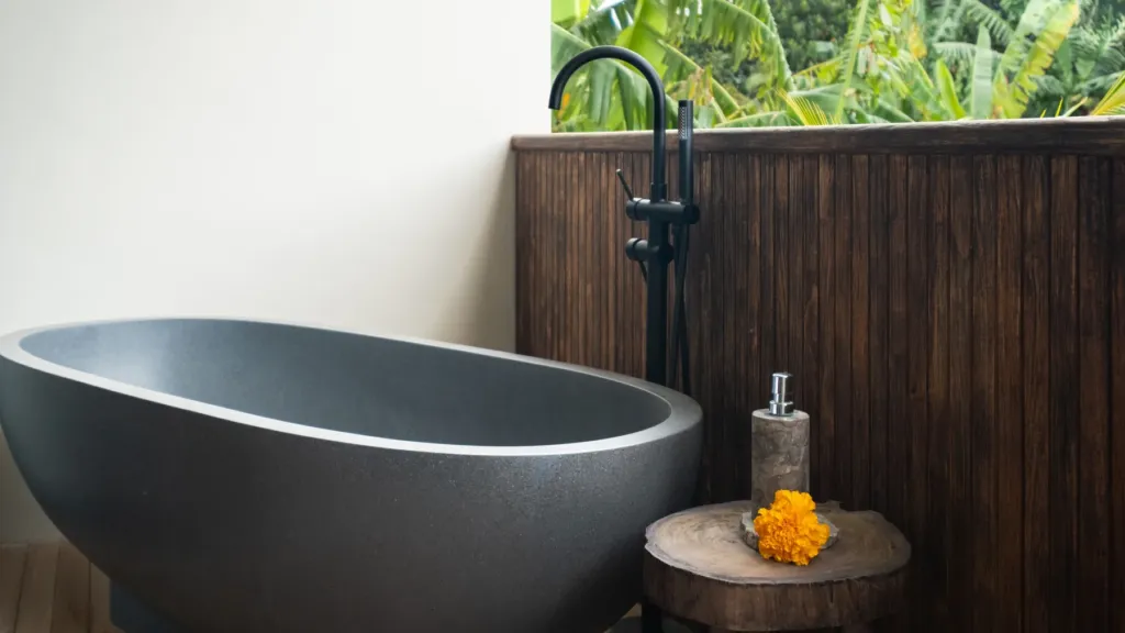 River-stone bathtub on the Bedroom 2 balcony at Villa Jaxé, a 5-bedroom private-pool villa in Bingin, Bali